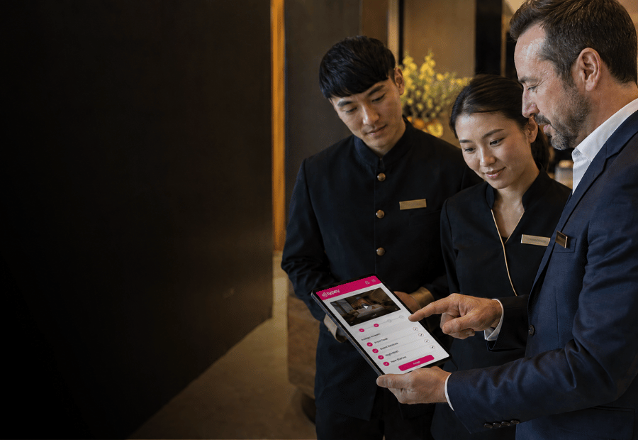 Hotel manager assigning a Typsy video course to team members on a tablet.