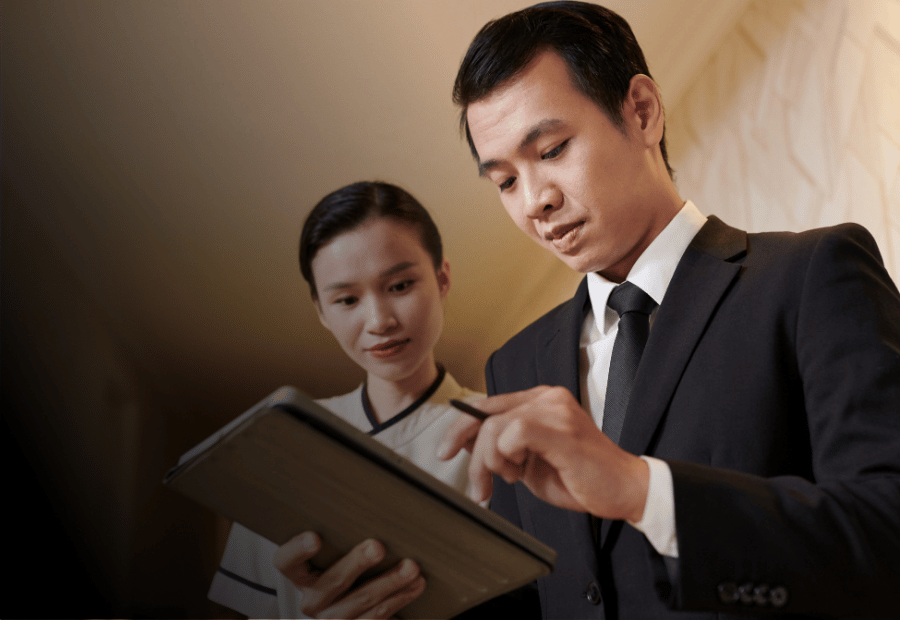 Hotel team members accessing mobile learning together on a tablet.