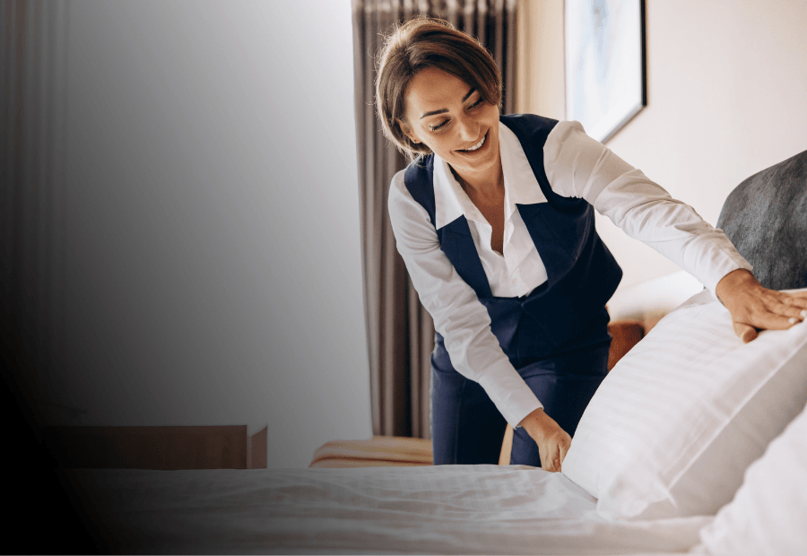 Housekeeping team member accessing operational guidance while preparing a guest room during service