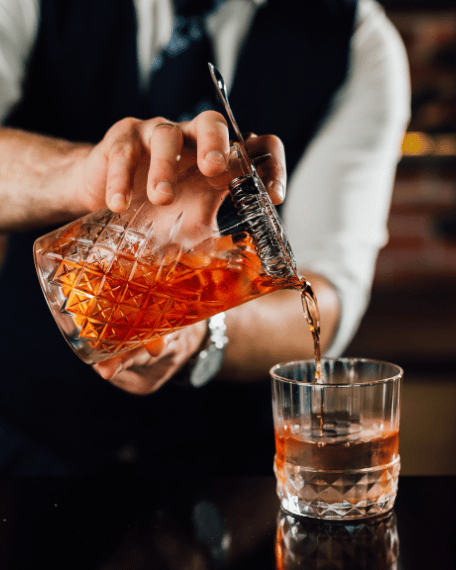 Bartender preparing a cocktail using professional beverage service techniques