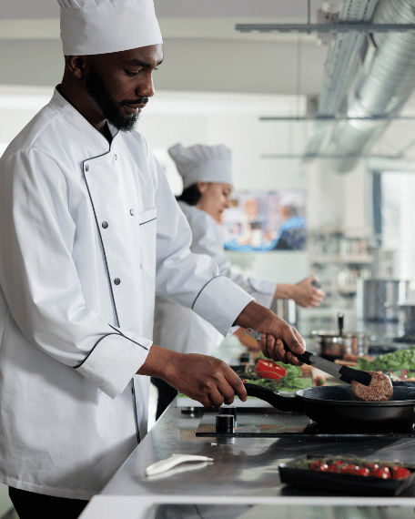 Professional chef preparing food using consistent culinary techniques and kitchen standards