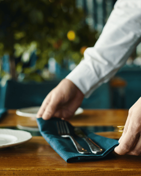 Restaurant team member preparing a table to deliver excellent guest service