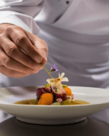 Chef plating a dish while applying consistent culinary standards
