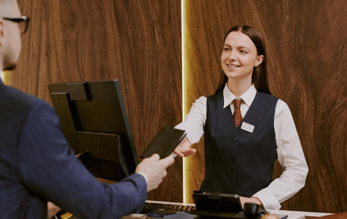Hotel front desk employee delivering consistent guest service during check-in