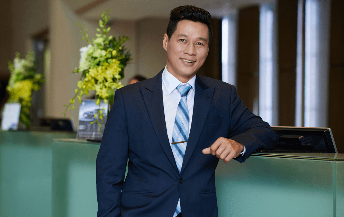 Hotel operations leader standing in a hotel lobby overseeing day-to-day operations and team performance