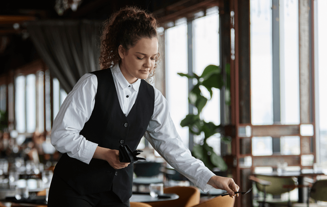 Restaurant team member preparing tables before service begins