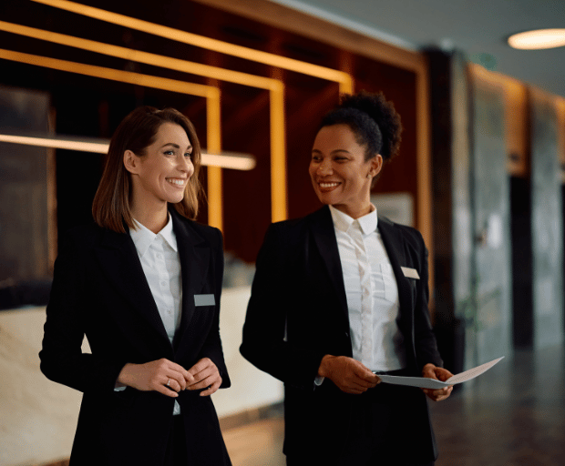 Two hospitality professionals collaborating while walking through a hotel lobby