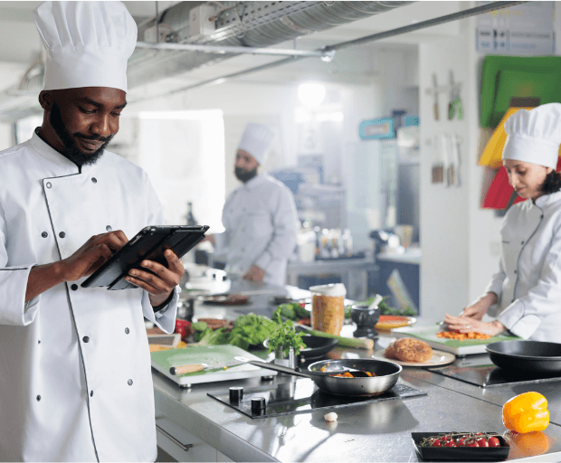 Kitchen team accessing digital operational guidance and compliance information during service